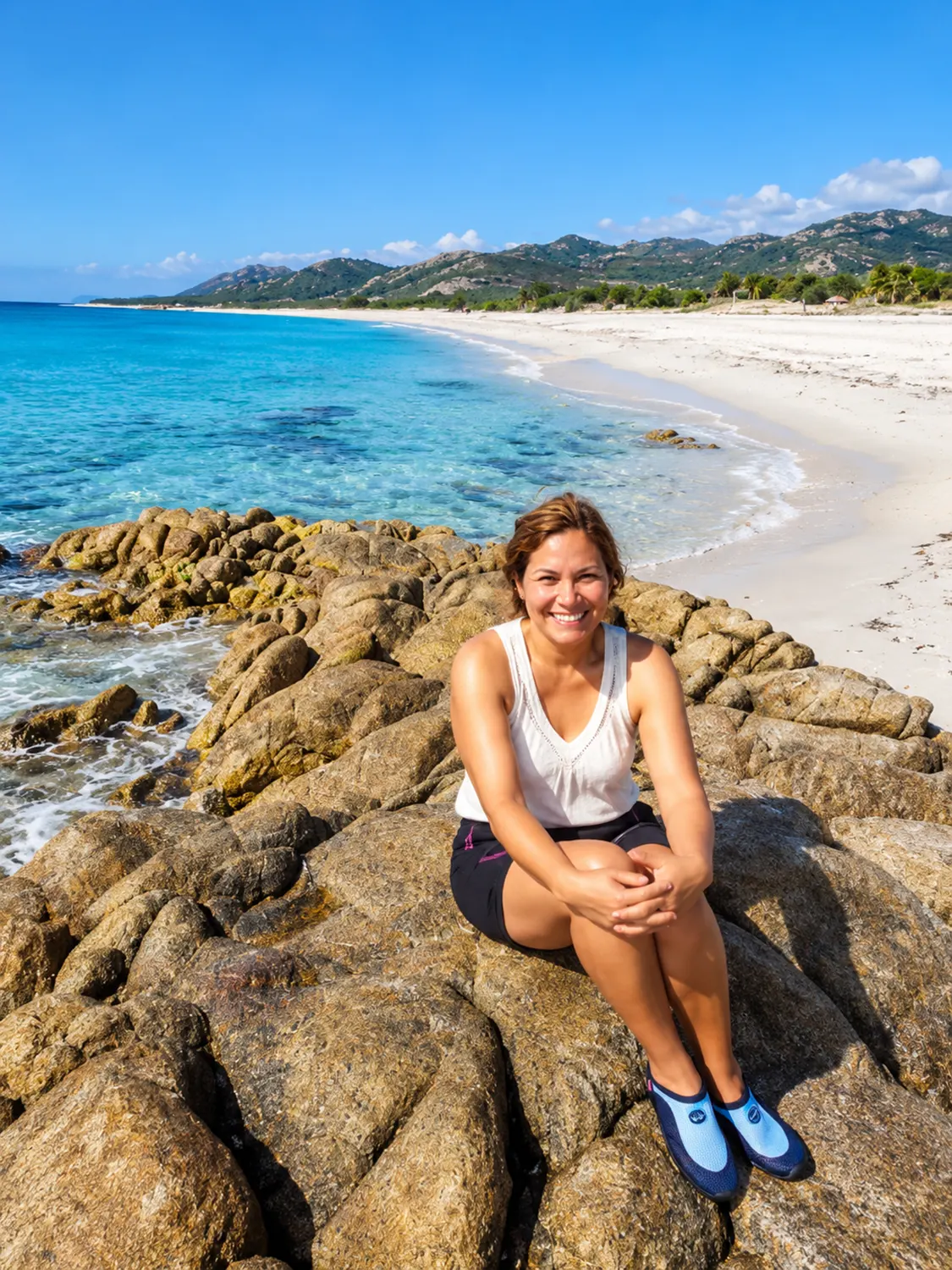 Joana, on the rocks at the water's edge on the Samaná coast