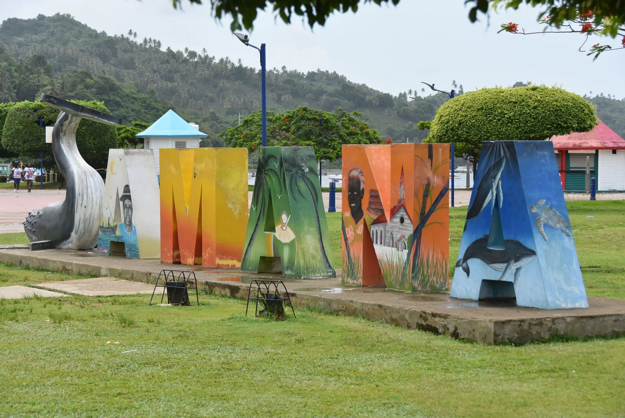 The painted SAMANÁ letters on the seafront promenade, with the whale tail sculpture behind